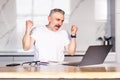 Happy excited old man winner excited by reading good news looking at laptop Royalty Free Stock Photo