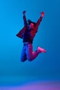Happy, excited, positive young man with curly hair, unshaved face, wearing casual clothes and jumping against blue Royalty Free Stock Photo