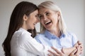 Happy excited senior mom and grownup daughter having fun together