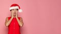 Happy excited shoÃÂked Christmas woman Santa posing against bright pink studio wall background. Xmas offer and gift concept