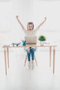 Happy excited successful businesswoman triumphing sitting in the workplace