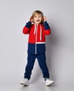 Happy excited surprised blond kid boy in red and blue sportwear with wide opened eyes holds his hand at her head Royalty Free Stock Photo