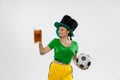 Happy excited woman in green yellow football kit holding beer mug and football ball supports favorite team. Soccer fans Royalty Free Stock Photo