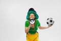 Happy excited woman in green yellow football kit holding beer mug and football ball supports favorite team. Soccer fans Royalty Free Stock Photo