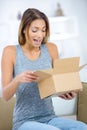 Happy excited woman at home unboxing gift Royalty Free Stock Photo