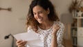 Happy excited woman reading paper letter, getting unbelievable good news