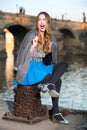 Happy excited woman sitting near river in the city