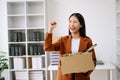 Happy and excited young beautiful Asian woman office worker celebrating her resignation, carrying her personal stuff. leaving job Royalty Free Stock Photo