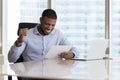 Happy excited young Black businessman getting good news letter