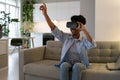 Happy excited young black woman enjoying virtual reality shopping experience while resting at home Royalty Free Stock Photo