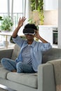 Happy excited young black woman enjoying virtual reality shopping experience while resting at home Royalty Free Stock Photo