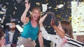 Happy excited young Caucasian female leader takes medical face mask off. Team celebrates with confetti at office meeting Royalty Free Stock Photo