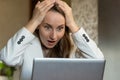 A happy, excited young female office worker raises her hands and screams with joy, celebrating a successful online Royalty Free Stock Photo