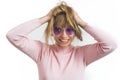 happy and excited young girl wearing circled purple sunglasses and holding her hair on her head, studio shot Royalty Free Stock Photo