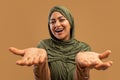 Happy excitement. Excited arab woman in hijab looking and spreading hands at camera, emotionally reacting to good news