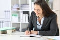 Happy executive writing notes on agenda at office Royalty Free Stock Photo