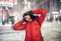 Happy exited woman having fun on city street of New York under the snow at winter time wearing hat and jacket. Royalty Free Stock Photo