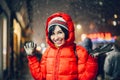 Happy exited woman having fun on city street of New York under the snow at winter time wearing hat and jacket Royalty Free Stock Photo