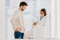 Happy experienced female vet examines jack russel terrier dog, gives advice how to care about animal. Male pet owner cures dog in