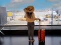 Happy young tourist woman holding the luggage and looking the airplane in the hall room