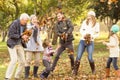 Happy extended family throwing leaves around