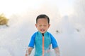 Happy face little Asian baby boy in swimming suit having fun in Foam Party at the pool outdoor Royalty Free Stock Photo