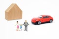 Miniature people as happiness family with wooden house and red car model toy in background. Royalty Free Stock Photo