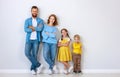 Happy family mother father and children daughter and son  near an   grey blank wall Royalty Free Stock Photo