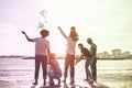 Happy familes flying with kite and having fun on the beach - Parents playing with children outdoor - Love and holidays concept - Royalty Free Stock Photo