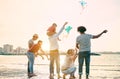 Happy familes flying with kite and having fun on the beach - Parents playing with children outdoor - Travel,love and holidays Royalty Free Stock Photo