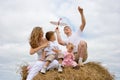 Happy family with aircraft on haystack summertime