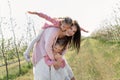 Happy family in the Apple orchard. Mom and two twin daughters have fun and hug Royalty Free Stock Photo