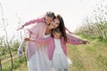 Happy family in the Apple orchard. Mom and two twin daughters have fun and hug Royalty Free Stock Photo