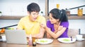 Happy family. Asian lovely couple, beautiful woman and handsome man are having breakfast in the kitchen Royalty Free Stock Photo