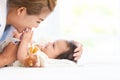 Happy family. Asian mother touching her adorable Caucasian newborn 3 months old baby girl head, having fun playing together while Royalty Free Stock Photo
