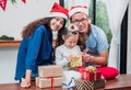 Happy family Asian family wear santa claus hat unwrap Christmas