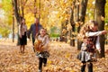 Happy family is in autumn city park. Children and parents running with leaves.. They posing, smiling, playing and having fun. Brig Royalty Free Stock Photo