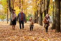 Happy family is in autumn city park. Children and parents running with leaves.. They posing, smiling, playing and having fun. Brig Royalty Free Stock Photo