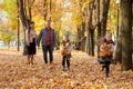 Happy family is in autumn city park. Children and parents running with leaves.. They posing, smiling, playing and having fun. Brig Royalty Free Stock Photo