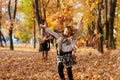 Happy family is in autumn city park. Children and parents running with leaves.. They posing, smiling, playing and having fun. Brig Royalty Free Stock Photo