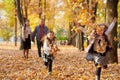 Happy family is in autumn city park. Children and parents running with leaves.. They posing, smiling, playing and having fun. Royalty Free Stock Photo