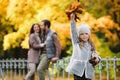 Family walk in autumn park. Loving parents of little girl hug outdoors in forest with colorful trees Royalty Free Stock Photo