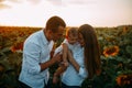 Happy family with baby has a fun and plays in the sunflower field Royalty Free Stock Photo