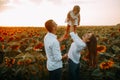 Happy family with baby has a fun and plays in the sunflower field Royalty Free Stock Photo