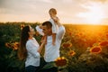 Happy family with baby has a fun and plays in the sunflower field Royalty Free Stock Photo