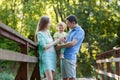 Happy family with baby in park on bridge Royalty Free Stock Photo