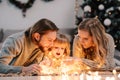 Happy family with baby playing with garlands while lying on the floor. Royalty Free Stock Photo