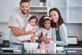 Happy family, baking and learning while teaching girl to bake in kitchen counter, love and fun together in home. Dad