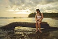 happy family at the beach a mother child daughter having fun at sunset sit on tree Royalty Free Stock Photo