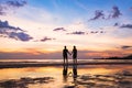 Happy family on the beach, silhouette of couple at sunset, man and woman Royalty Free Stock Photo